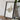 a framed map of Big Bend National Park, with a camera and some books placed on a wooden table in front of it.