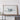 a large white framed artwork depicting a stylized, abstract representation of a landscape or natural scene.
