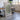 a large framed map of a mountainous region, with a wooden table and chairs in the background.