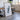 a large framed artwork depicting a black and white abstract shape, placed in a room with a wooden table and chairs.
