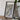 a framed map of the Appalachian Trail, with a camera and some books placed on a wooden table in front of it.