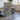 a large, rectangular, textured piece of art or painting displayed in a room with a wooden table and chairs.