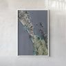The image is a framed aerial view of a coastal area, depicting a mix of land and water features.