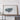 a large framed artwork depicting a map of a region, placed on a wooden shelf against a white wall.