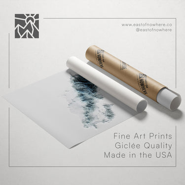 a roll of paper with a drawing of a landscape on it, along with a tube of paper and a website address for fine art prints.