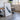 a large framed artwork depicting a mountain range, placed in a room with a dining table and chairs.