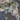 The image is a satellite view of a mountainous region with a mix of green and brown terrain, surrounded by water.