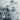 The image is a close-up of a snowy, mountainous landscape, with a textured, wintry appearance.