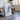 a large white framed artwork depicting a mountain or landscape scene, placed in a room with a wooden table and chairs.