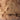 a close-up view of a textured surface, possibly a wall or a piece of pottery, with a variety of small holes and cracks. The surface appears to be made of a material that resembles clay or plaster, with some areas showing signs of wear or damage. The image does not contain any discernible text or specific actions, and the overall composition is simple and straightforward.