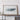 a large framed artwork depicting a map of Tennessee, with a wooden shelf below it holding a camera and a suitcase.
