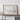 a large framed map of a coastal area, with a wooden shelf below it.