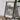 a framed map of Vancouver, Canada, with a potted plant and a camera on a wooden table in the foreground.