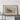 a large framed map of the Kilauea volcano, a prominent landmark in Hawaii. The map is displayed on a wooden shelf, and there are some personal items, such as a camera and a book, placed nearby.