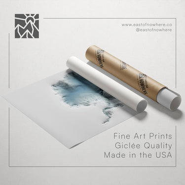 a roll of paper with a watercolor painting of a landscape on it, along with a cardboard tube and a text overlay promoting fine art prints made in the USA.