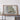 a large framed map of Missouri, with a wooden shelf below it holding a camera and some books.
