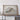 a framed geological map of the United States, with a wooden shelf below it.