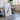 a large, framed artwork depicting a black and white abstract design, placed in a room with a wooden table and chairs.