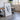 a large, framed artwork depicting a black and white abstract design, placed in a room with a wooden table and chairs.