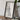 a framed map of Chicago, Illinois, with a camera and some books placed on a wooden table in front of it.