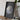 A framed image of the Earth is displayed on a wooden table, accompanied by a camera and some books.
