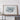 a large framed map of Nigeria displayed on a wooden shelf against a white wall.