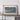 a large framed picture of a coastal area, with a wooden shelf below it holding a camera and a book.