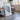 a large framed artwork depicting a mountain or landscape scene, placed in a room with a dining table and chairs.