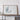 a large framed artwork of a map, displayed on a wall above a wooden table.
