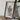 a framed map of Scotland, with a camera and some books placed on a wooden table in front of it.