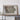 a large framed map of Iowa, with a wooden shelf below it holding a camera and some books.