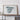 a large, framed map of Spain displayed on a wooden shelf against a white wall.