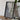 a framed map of a coastal region, with a camera and a book on a wooden table in front of it.