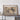 a large framed map of the Grand Canyon, which is displayed on a wall above a wooden table.