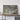a large framed map of the Great Lakes region, with a wooden shelf below it holding a camera and some books.