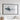 a large black framed picture hanging on a white wall, depicting a stylized representation of a wave or ocean.