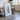 a large framed artwork depicting a large abstract shape, placed in a room with a wooden table and chairs.